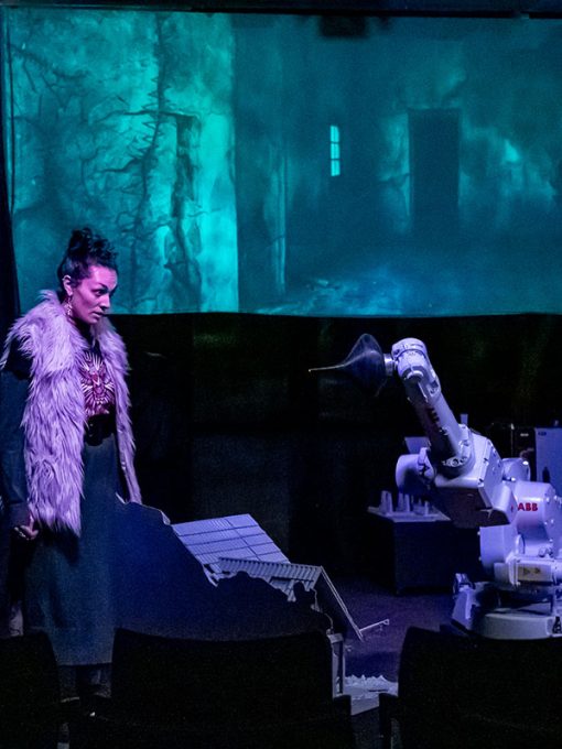 actriz en un teatro frente a un robot
