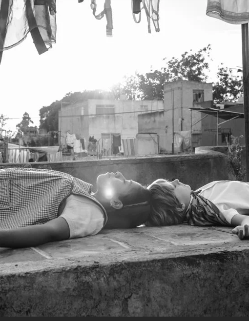 still de la película roma, 2 niñas acostadas una al lado de la otra