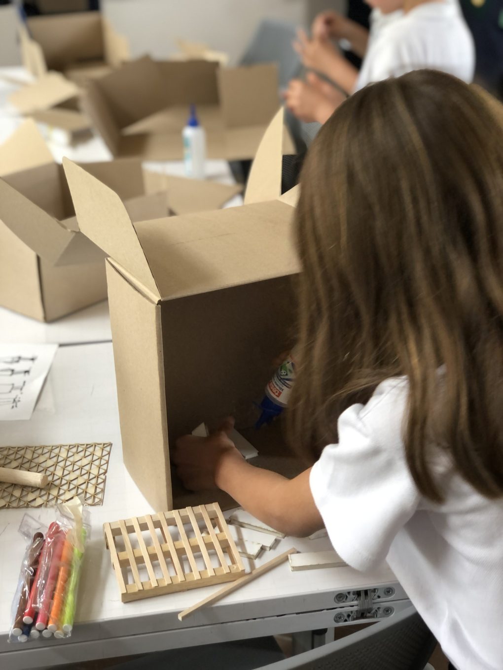 niña haciendo un edificio de cartón
